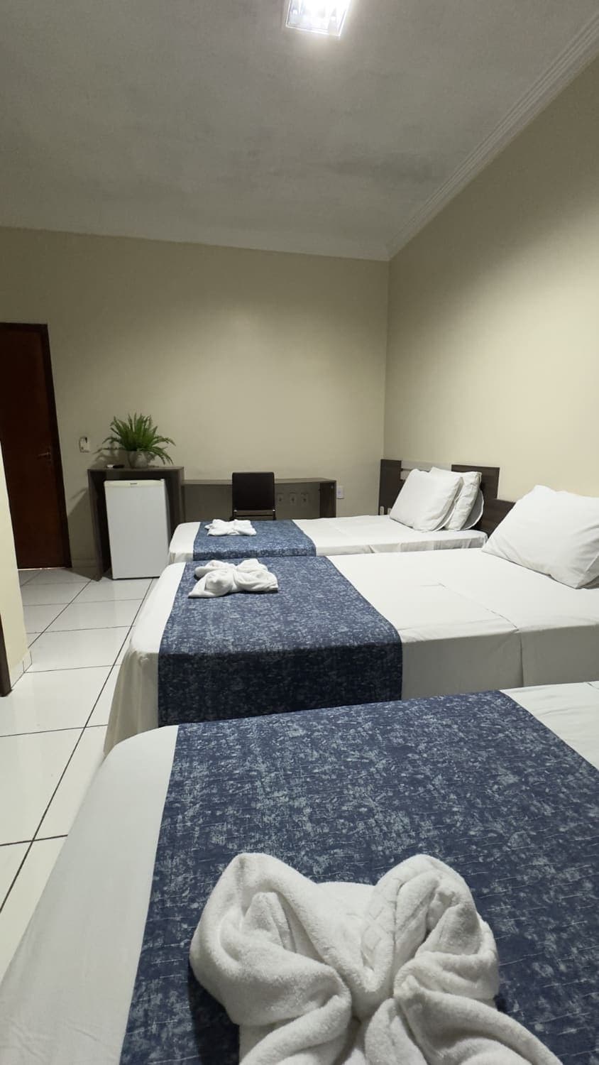 Acomodação do Palace Hotel com cama feita e ambiente limpo