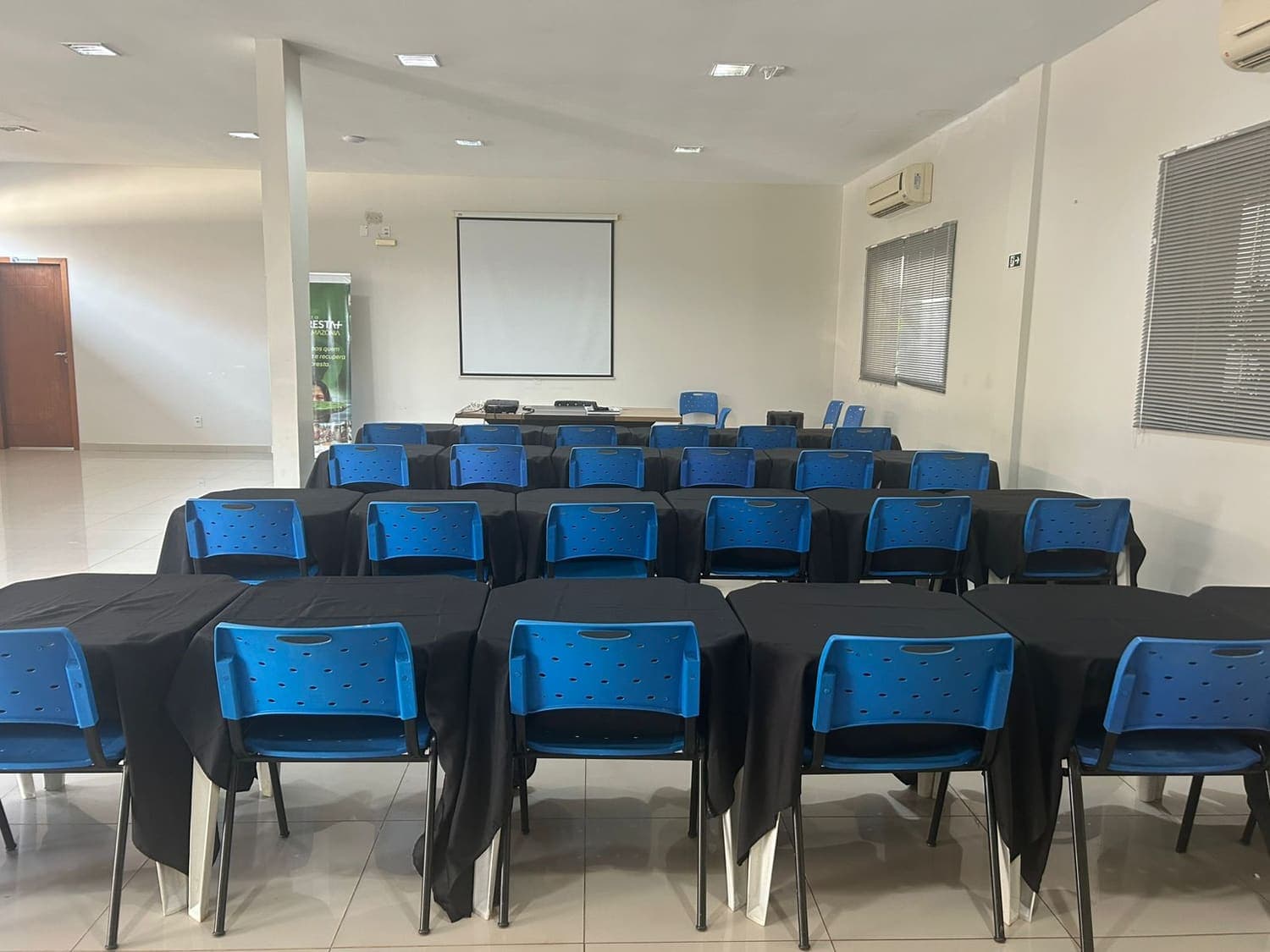 Auditório montado em formato de treinamento com projetor