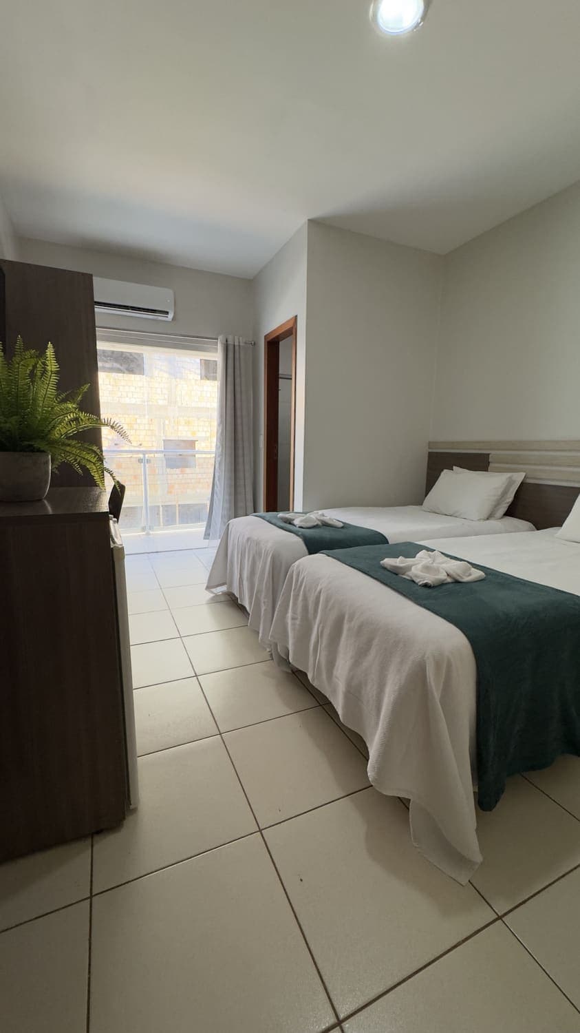 Quarto com duas camas de solteiro e varanda no Palace Hotel
